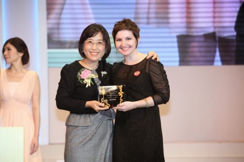 EIU alumna Amy Simpson accepts a 2013 Employee of the Year award from the CEO of HESS International Educational Group at the company’s year-end banquet in Taipei, Taiwan.